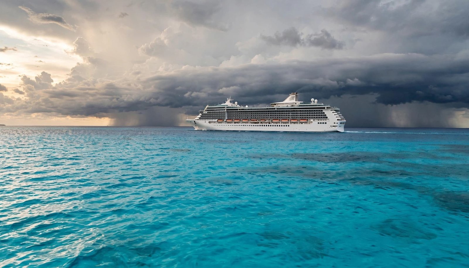 A large white cruise ship sails on turquoise water beneath dark storm clouds.